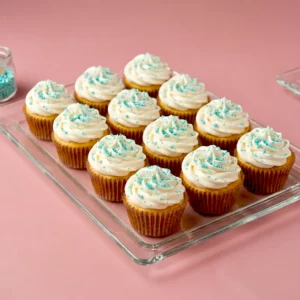 Mini cupcakes au glaçage blanc décorés de perles bleues, parfaits pour un buffet élégant et gourmand